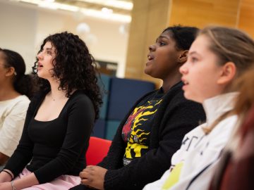 A group of young people rehearse in a choir